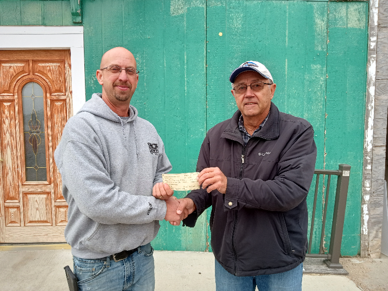 David Tejral, president of the Nance County Foundation, presents the grant to Bob Green, director and coach of the Twin River Youth Football Program. Photo provided