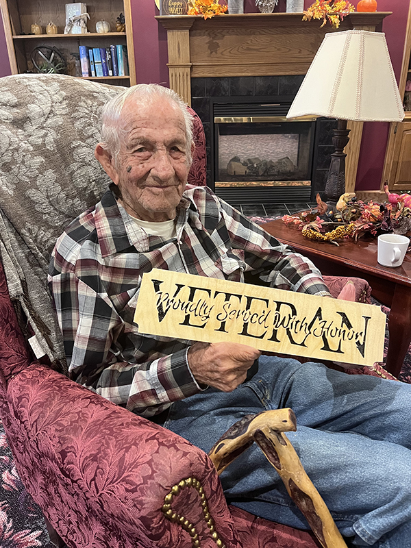 Larry Phillips is pictured with one of the signs he has made. NCJ photo by April Carr