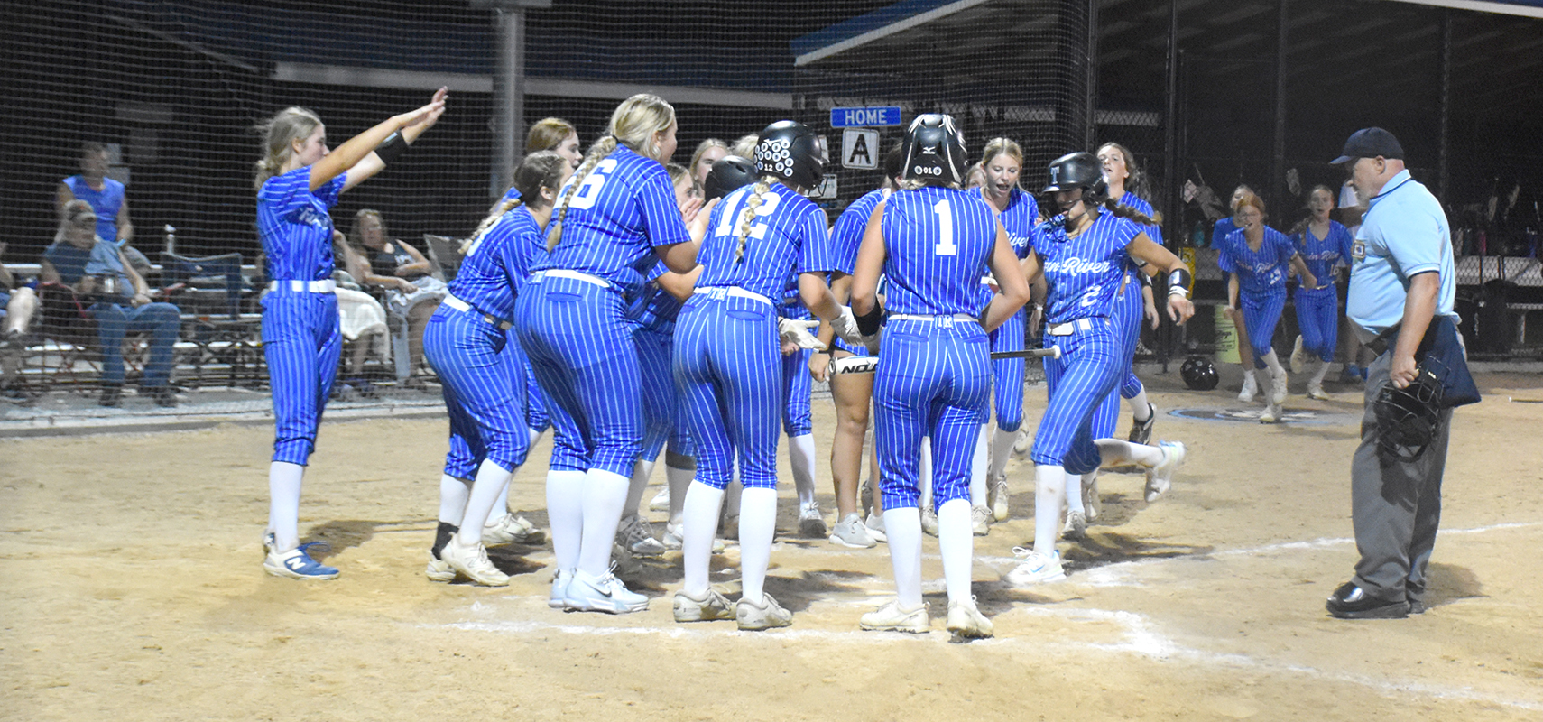 Twin River waits as JLee Van Driel completes her trip around the bases after her home run against Blue River. NCJ photo by Beth Sparrow