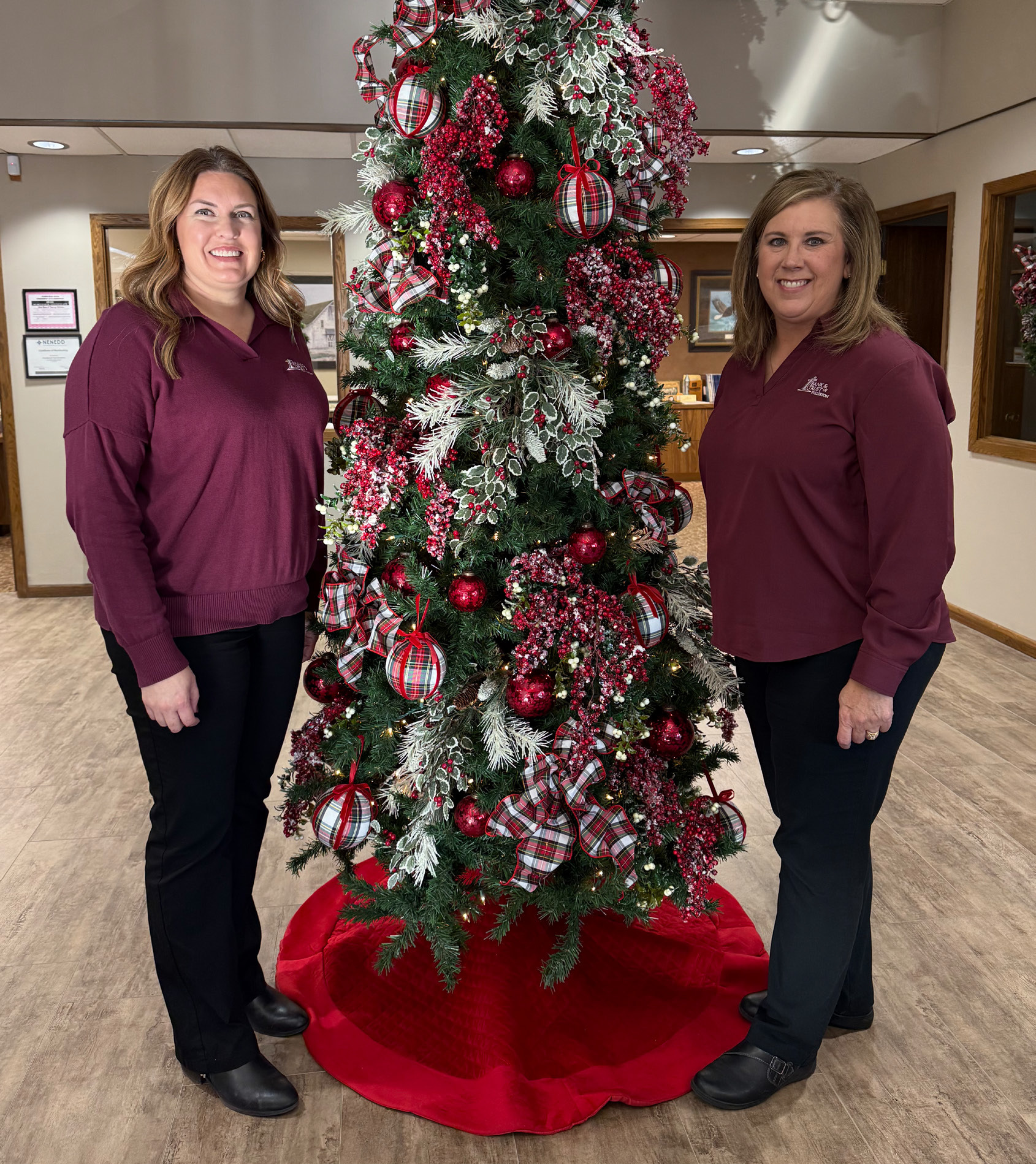 Beth Sonderup (left) and Lori Cornwell stand next to the Tree of Love located inside the 1st Bank &amp; Trust branch in Fullerton. NCJ photo by Rick Holtz