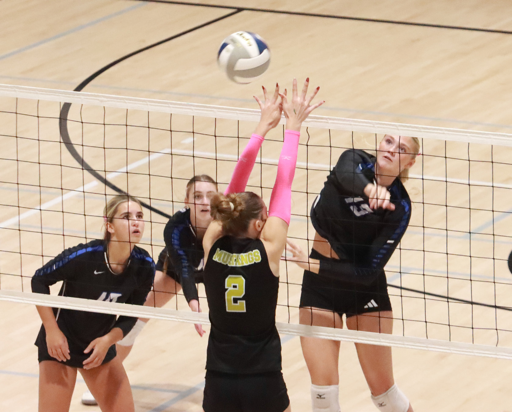 Grace Yrkoski hits the ball past the McCool Junction blocker on her way to a team-high 7 kills as the Titans beat the Mustangs in straight sets. NCJ photo by Ken Kush