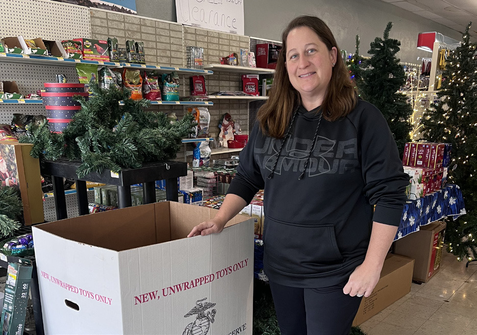 Sarah Ciancio stands by the Toys for Tots donation box at Ciancio Hardware. NCJ photo by April Carr