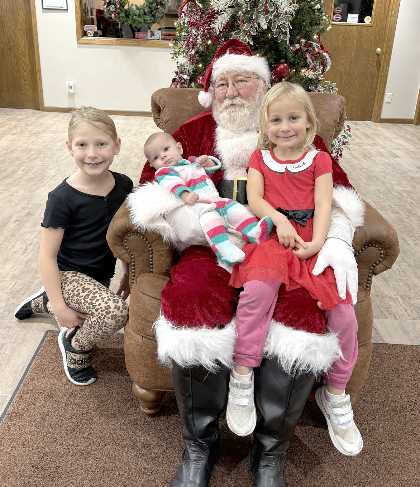 Everly, 8, Freya, 4, and Ingrid Schock, 4 months, visit with Santa during Old-Fashioned Christmas in Fullerton.