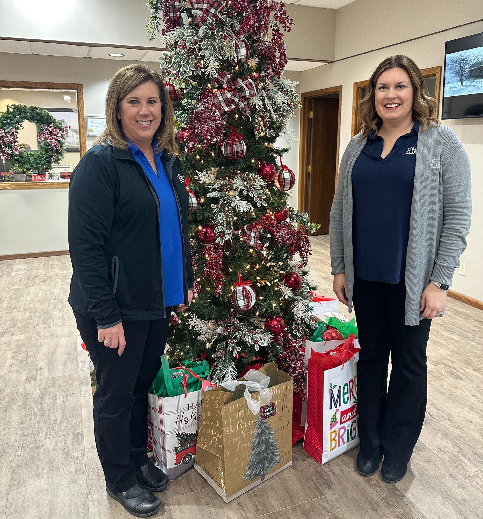 Lori Cornwell (left) and Beth Sonderup stand next to the Tree of Love located inside the 1st Bank & Trust branch in Fullerton. NCJ photo by Rick Holtz
