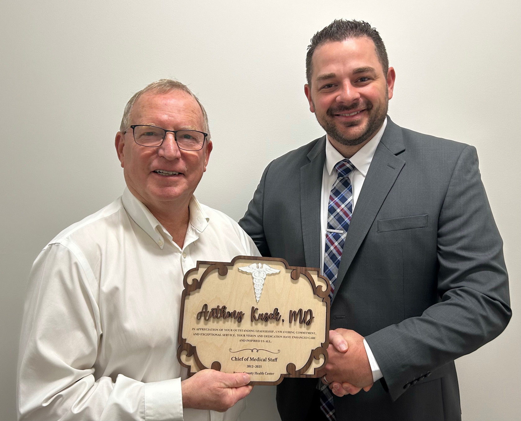 Caleb Poore, CEO present plaque to Anthony Kusek, MD.
