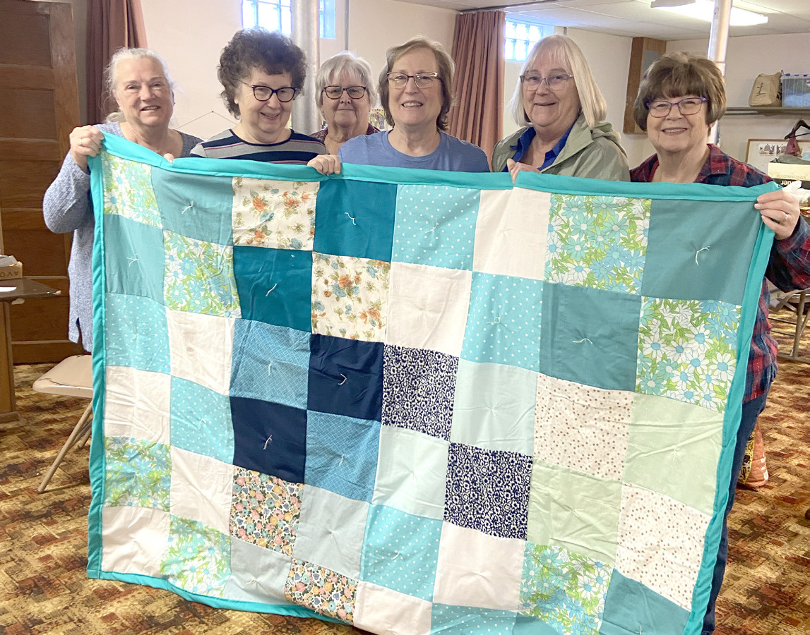 Liz Keehn, Pat Kolm, Judy Hunt, Kay Swerczek, Sue McIntyre, Diane Buettner show off one of their quilts. Photo provided