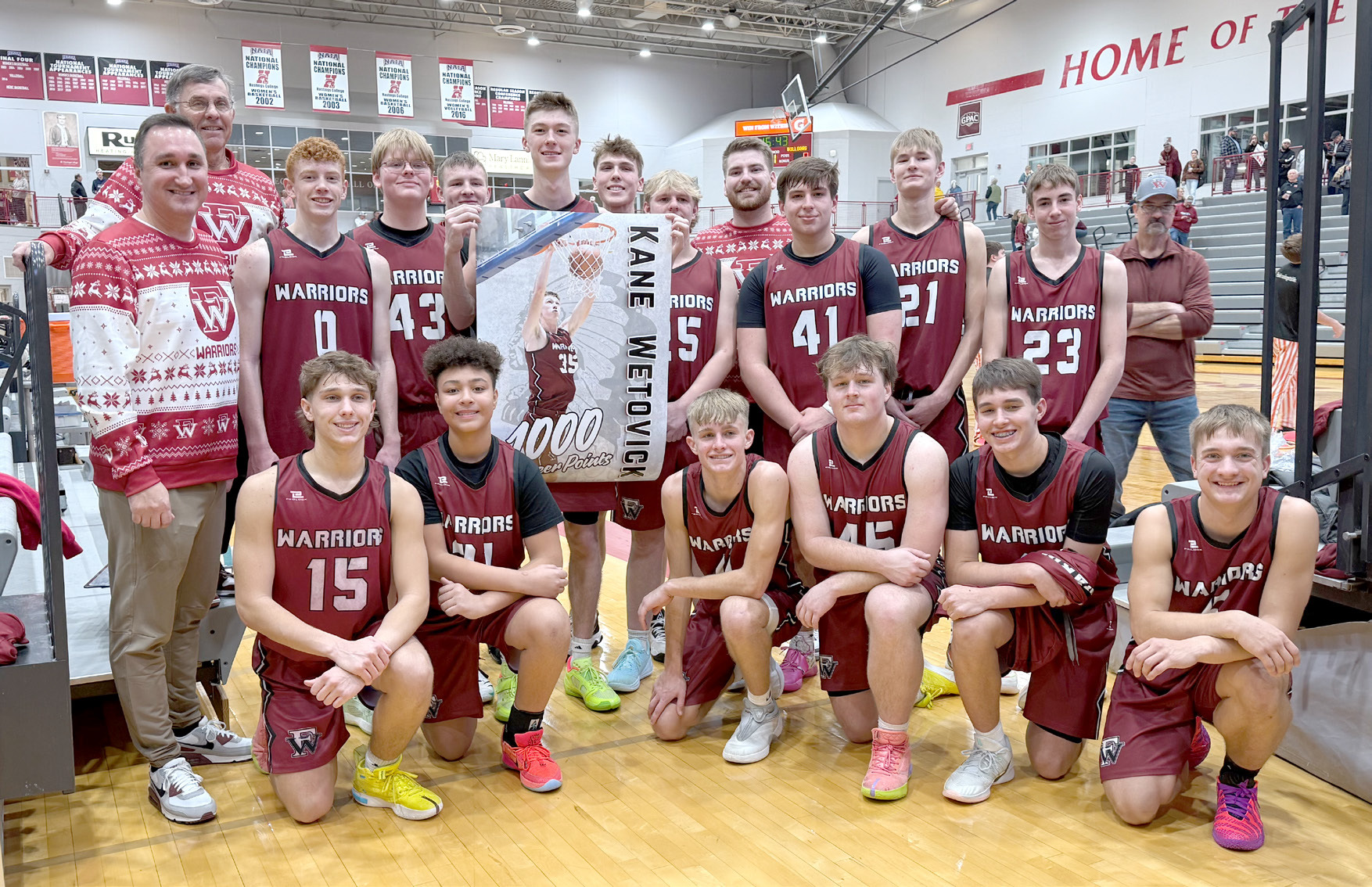 The Warriors celebrate with Kane Wetovick after Saturday’s 52-37 win over Silver Lake. Wetovick scored his 1,000th career point in the contest. NCJ photo by Rick Holtz