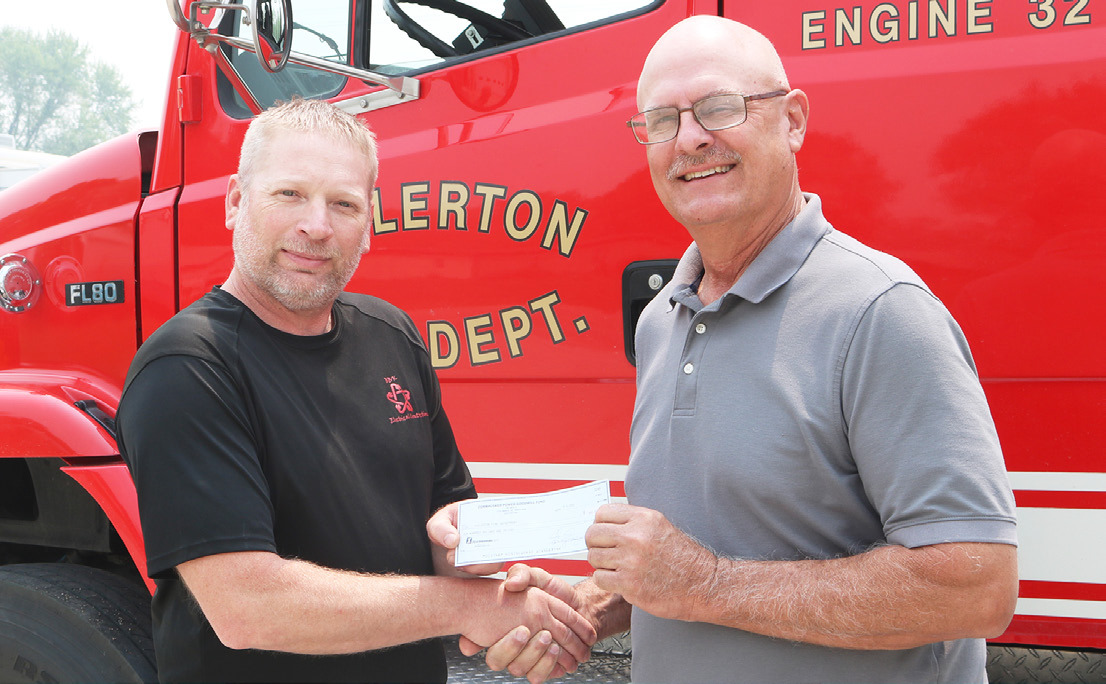 Cornhusker Public Power District Trustee Marc Swantek (right) presents $600 to Fullerton Volunteer Fire Department for wildland masks. Accepting the check is Assistant Fire Chief Brandon Harter (left).