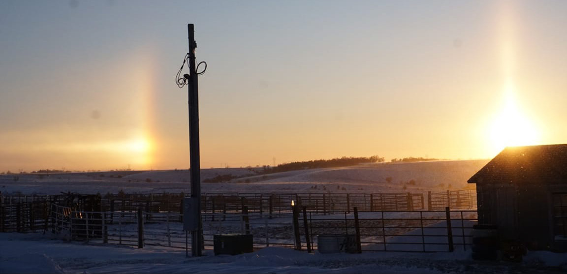 Sundogs appear when sunlight passes through a thin veil of ice crystal clouds (usually cirrus or cirrostratus), and the ice acts as a prism, refracting the light. A sundog is seen about 22 degrees to the left or right of the Sun. Sundogs often form in pairs on either side of the Sun. NCJ photo by Cathy Cook