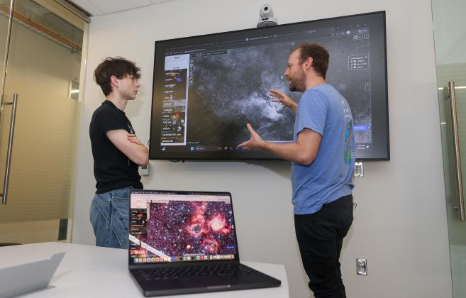 UNK junior Andrew Yemma, left, and associate professor Brandon Marshall discuss their astrophysics research inside Discovery Hall. Photo by Erika Pritchard, UNK Communications