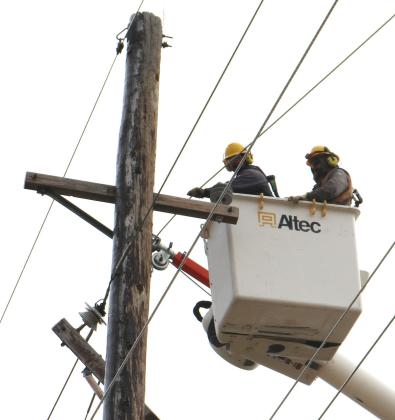 Cornhusker Public Power District line technicians Corey Boryca (left) and Griffin Babb (right) repair a damaged cross-arm southwest of Lindsay. Photo provided