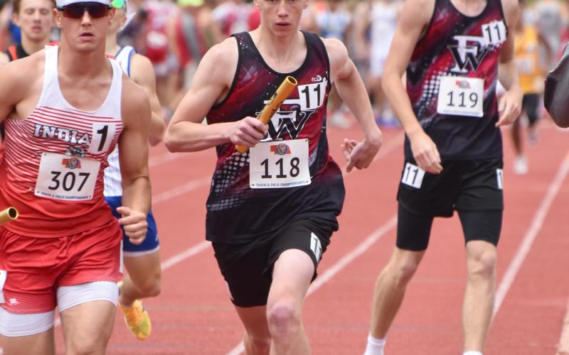 Jacob Maxfield takes off after receiving the baton from Kane Wetovick in the 4x800-meter relay. Both also ran legs on the 4x400-meter relay team. NCJ photo by Beth Sparrow
