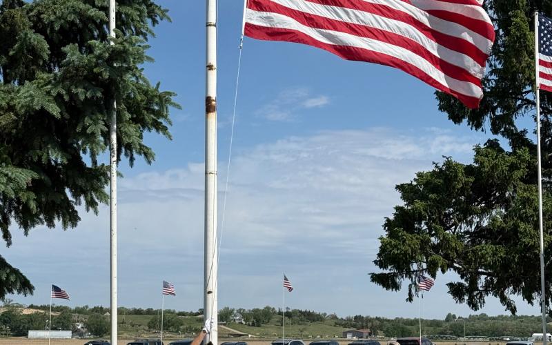 Russ Sprague and Chuck Delancey lower the flag into place on Monday.