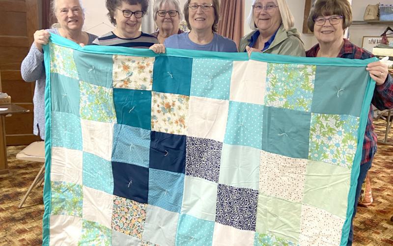 Liz Keehn, Pat Kolm, Judy Hunt, Kay Swerczek, Sue McIntyre, Diane Buettner show off one of their quilts. Photo provided