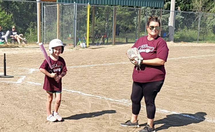Americus Nelson gets ready to bat with help from Coach Christina Robb. Photo provided by Tessa Nelson