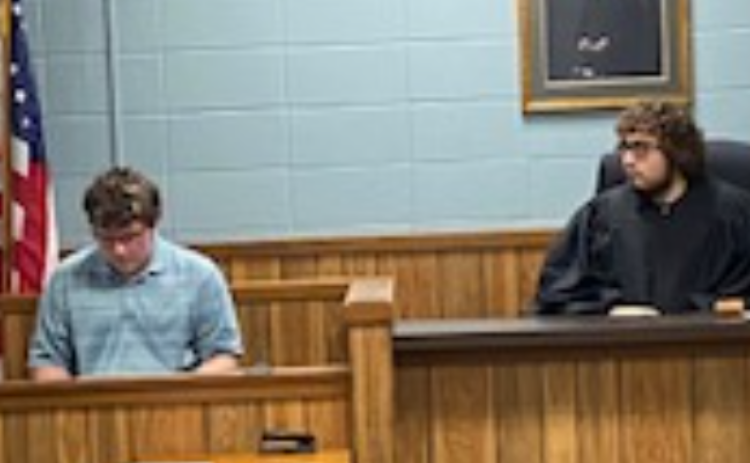 Twin River student Ryder Kleckner sits in as judge while questioning witness Elijah Wireman of Fullerton at the mock trial.