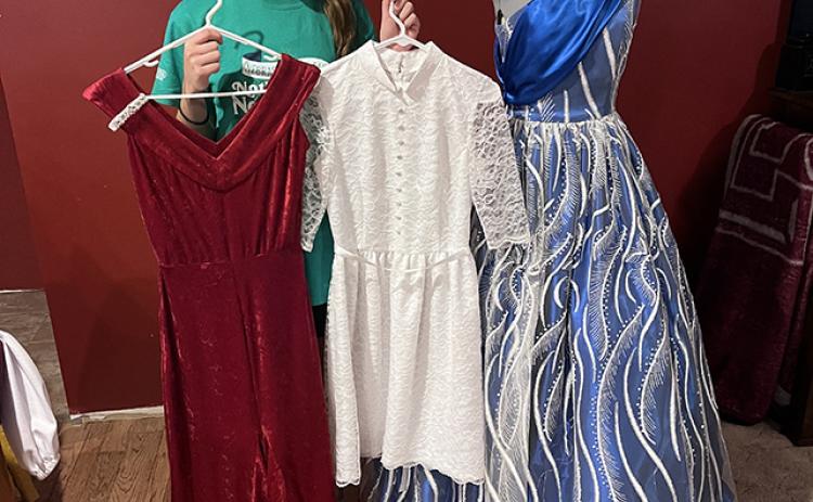 Josie Williams stands with just three of the many dresses she has made. NCJ photo by April Carr