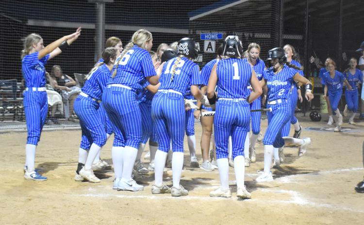 Twin River waits as JLee Van Driel completes her trip around the bases after her home run against Blue River. NCJ photo by Beth Sparrow