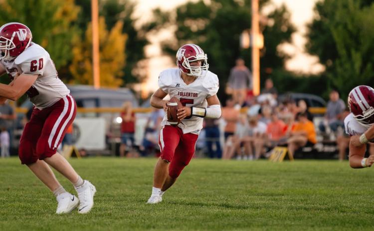 Fletcher Dubas looks down field for the open receiver against Palmer. The senior quarterback connected with five different receivers on Friday. NCJ photo by Whitney Busch