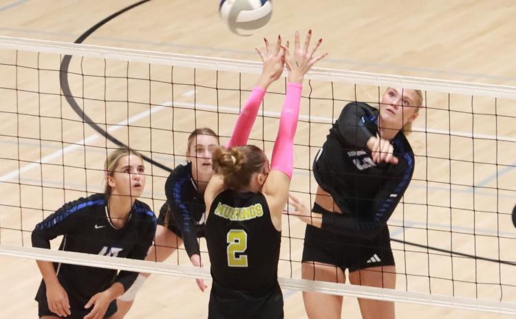 Grace Yrkoski hits the ball past the McCool Junction blocker on her way to a team-high 7 kills as the Titans beat the Mustangs in straight sets. NCJ photo by Ken Kush