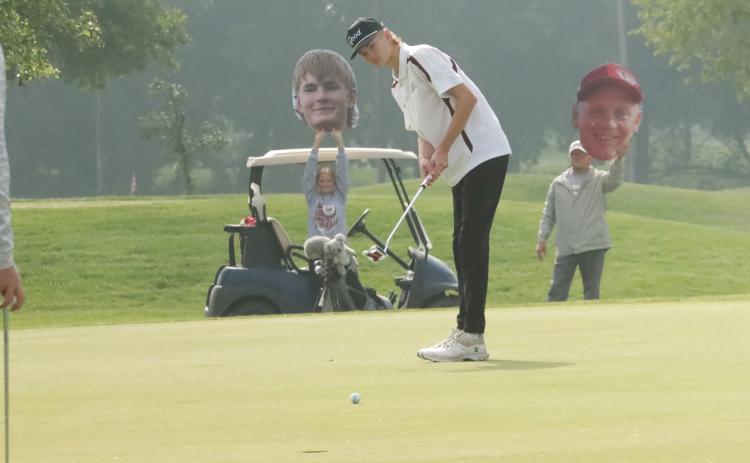 Cayden Scheffler watches his putt roll towards the cup with his fans cheering him on in the back ground. NCJ photos by Ken Kush