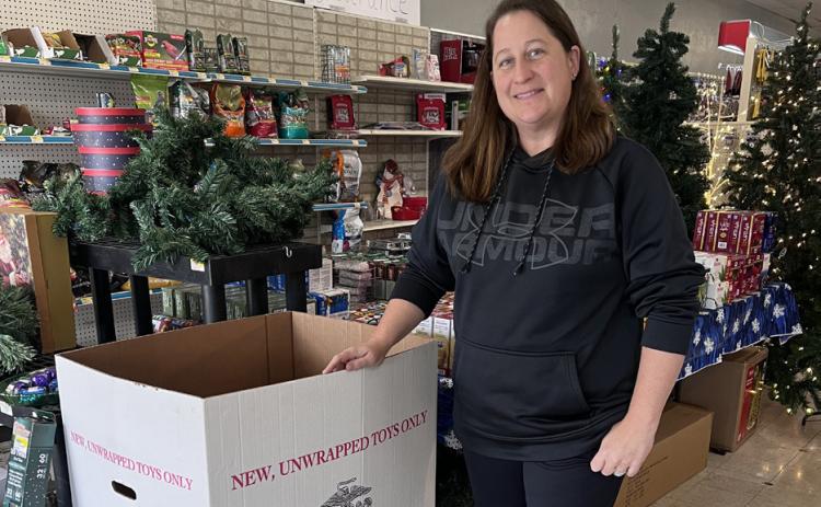 Sarah Ciancio stands by the Toys for Tots donation box at Ciancio Hardware. NCJ photo by April Carr