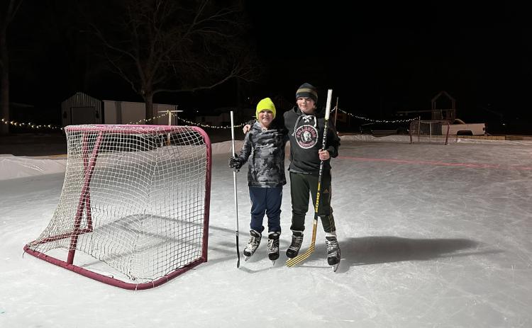 Beed brothers, Sam (left) &amp; Wyatt (right) stand proudly on their backyard ice rink.