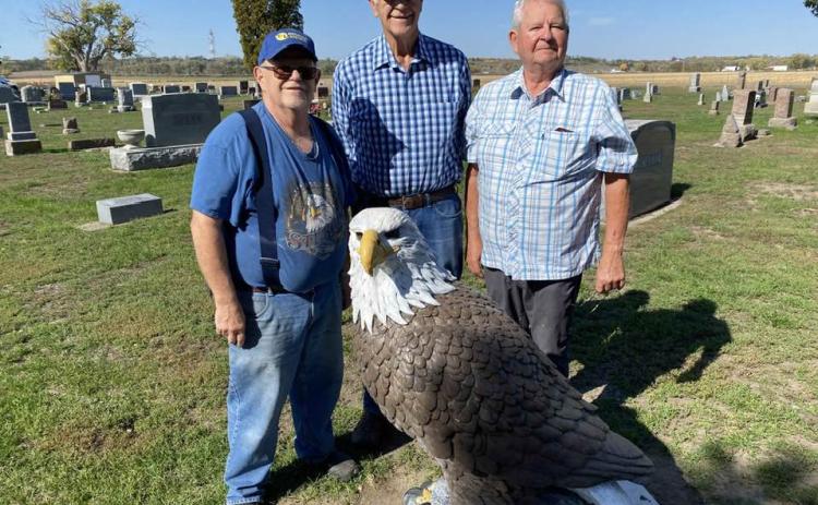 Ron Delaney, Dennis McCoig and Butch Horacek stand by the eagle statue that previously was located in the lateTom Delaney’s yard. The statue was moved to the Fullerton Cemetery on Oct. 23. Photo provided by Ron Delaney