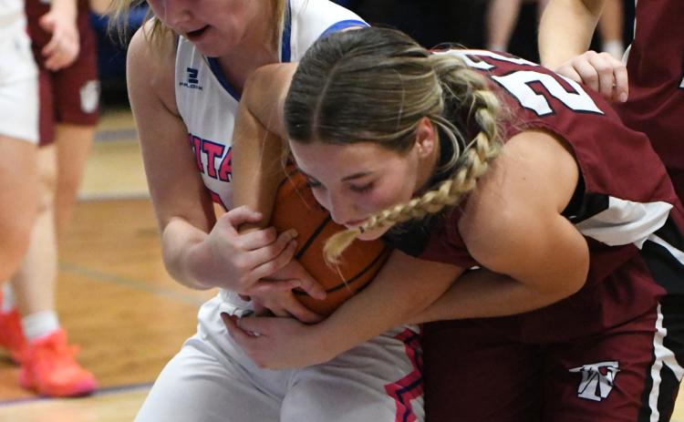 County bragging rights were up for grabs on Friday in Genoa. Delaney Reeg and Isabel Norman both grab possession of a rebound. NCJ photos by Rick Holtz