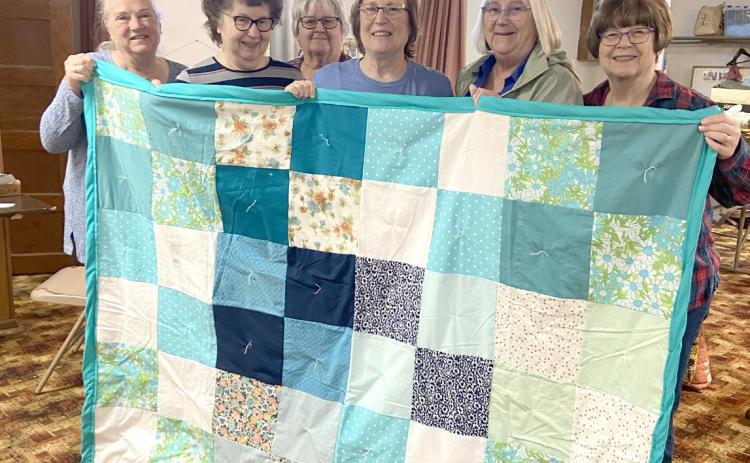 Liz Keehn, Pat Kolm, Judy Hunt, Kay Swerczek, Sue McIntyre, Diane Buettner show off one of their quilts. Photo provided