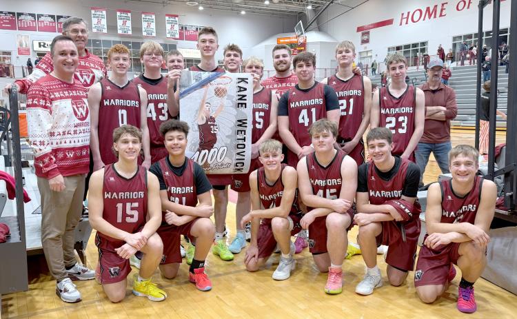 The Warriors celebrate with Kane Wetovick after Saturday’s 52-37 win over Silver Lake. Wetovick scored his 1,000th career point in the contest. NCJ photo by Rick Holtz