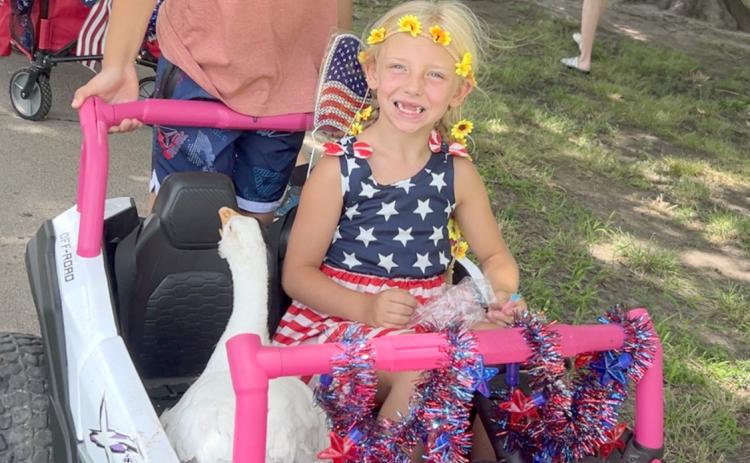 Aubrey Collins, 8, gives her goose Nibbles a ride during the Fourth of July sidewalk parade. Joining her on the ride was her cousin, Maverick Creutzberg. Photo provided